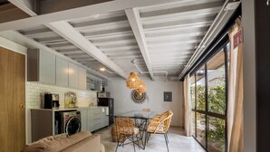 Eine moderne Küche mit Essbereich, einer Couch und einem großen Fenster.