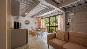 Ein modernes Interieur mit einer Couch, einem Esstisch, Stühlen und einer Küchenzeile.