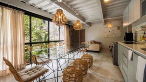 A modern kitchen with a dining area, large windows, and a view of greenery. - GARCIA 3 · Spacious four Bedroom apt with Garden (Oaxaca)