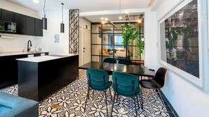 Een moderne keuken met een centraal eiland, zwarte kastjes en een vloer met een patroon.