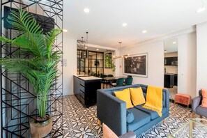 A modern living area with a sofa, a dining table, and a kitchen in the background. - INDEPENDENCIA 2 · Small and Modern Apt for four (Oaxaca)