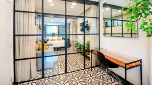 Een moderne kamer met een glazen scheidingswand, een bureau en een stoel.