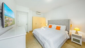 Een hotelkamer met een bed, een bureau, een televisie en een kledingkast.