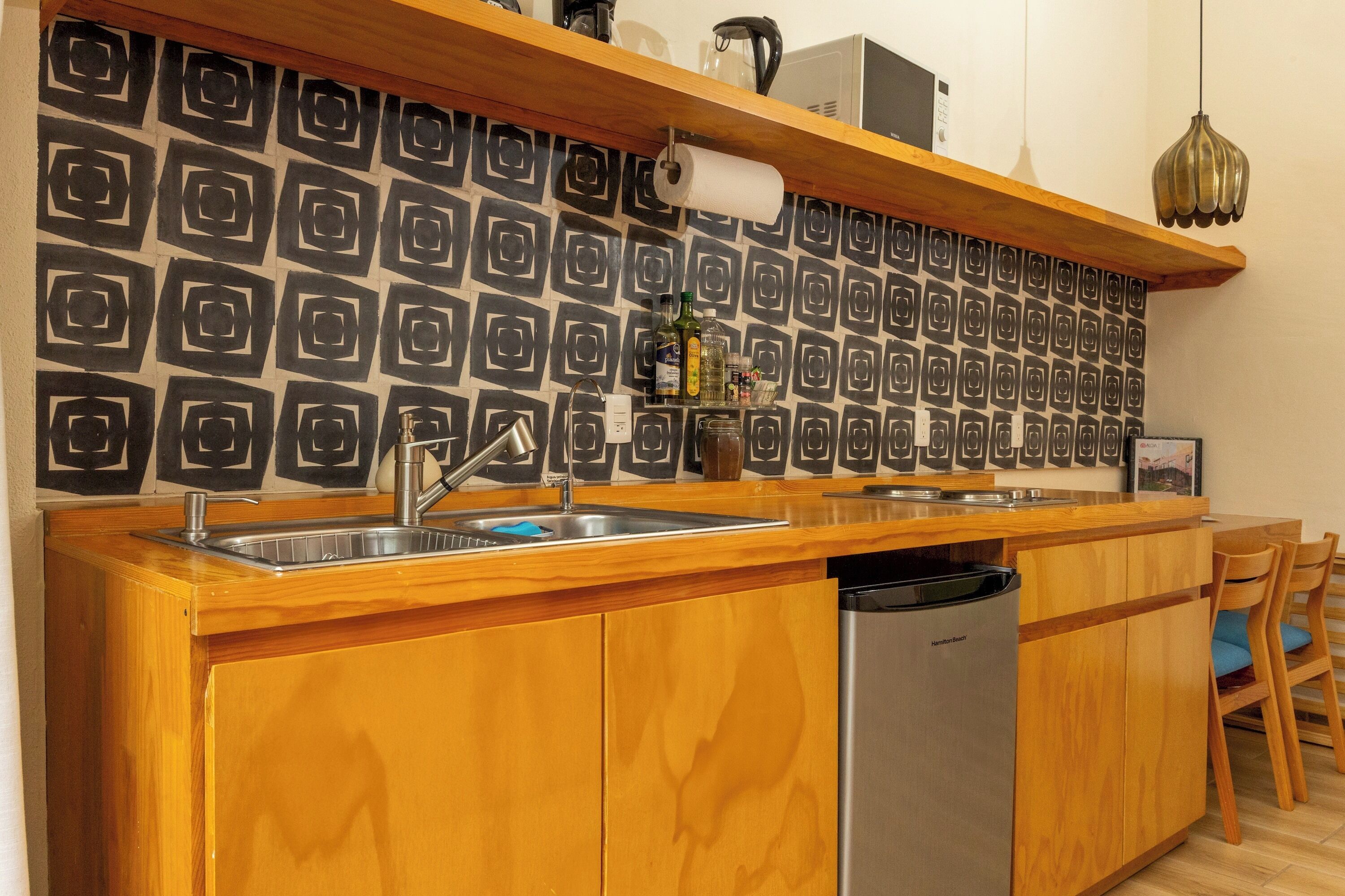 A kitchen with a wooden countertop, stainless steel sink, and a built-in dishwasher.