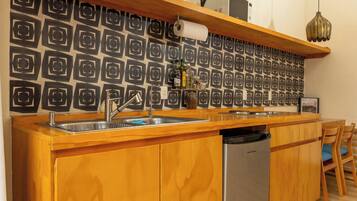 A kitchen with a wooden countertop, stainless steel sink, and a built-in dishwasher.