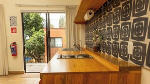 A kitchen with a wooden countertop, a sink, and a patterned wall. - REGIONES - CAÑADA · Charming Upper Floor Suite (Oaxaca de Juárez)