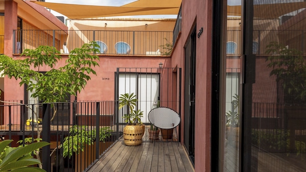A wooden deck with potted plants, a wicker basket, and a metal chair. - REGIONES - CAÑADA · Charming Upper Floor Suite (Oaxaca de Juárez)