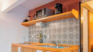 Une cuisine moderne avec des armoires en bois, un four à micro-ondes encastré et un pare-feu en carreaux.