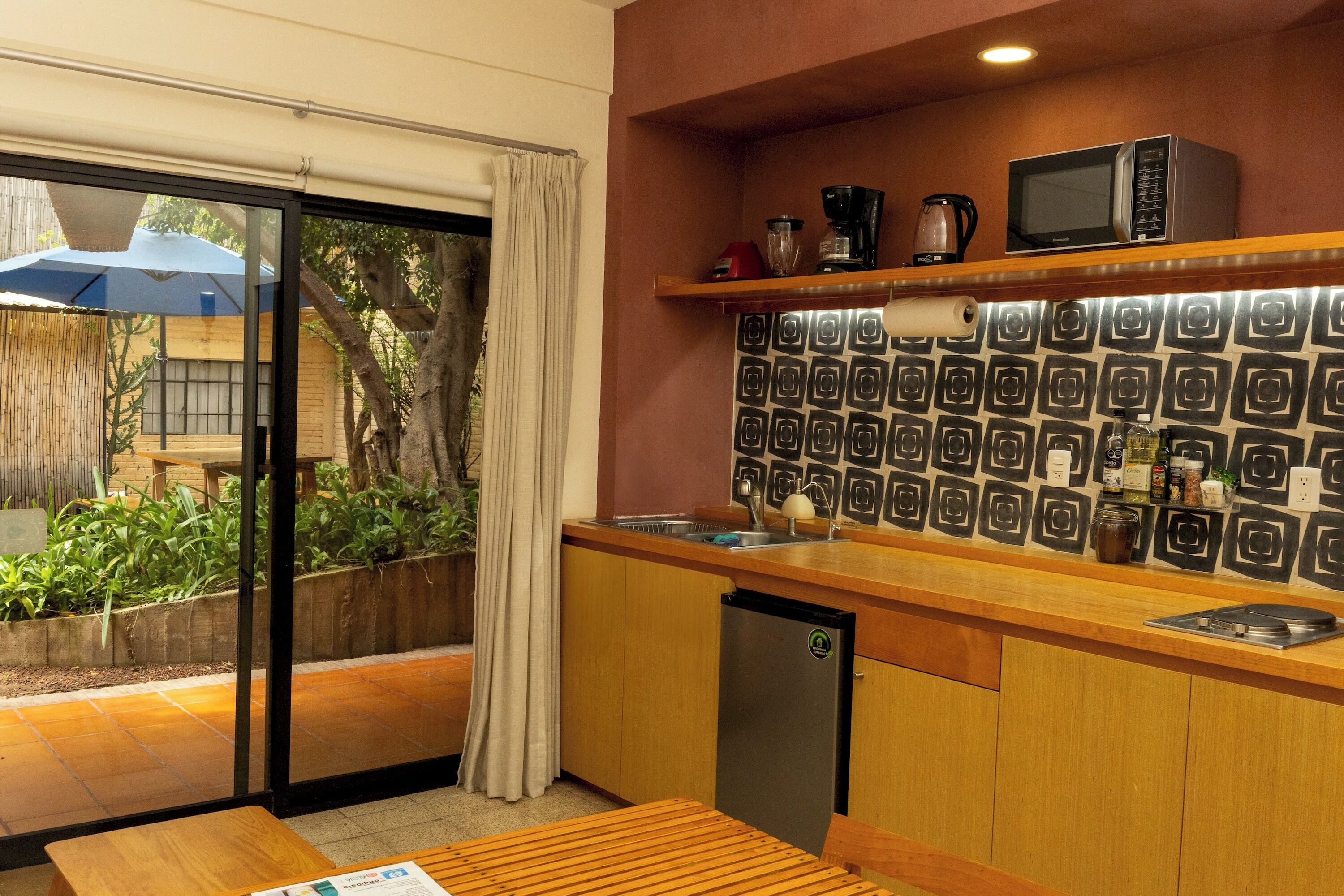 A kitchen with a microwave, coffee maker, and a refrigerator.