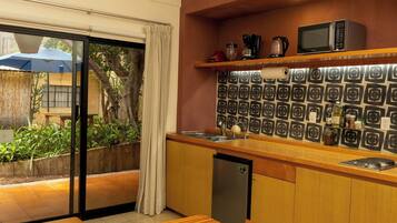 A kitchen with a microwave, coffee maker, and a refrigerator.