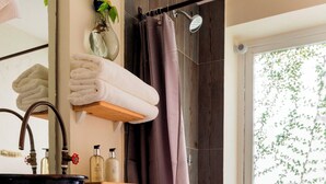 A bathroom with a toilet, a sink with a basin, a shower curtain, a window, and a wicker basket. - HIDALGO 3 · Group Stay 2 Blocks from Zócalo (Oaxaca)
