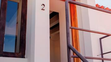 Un bâtiment avec le chiffre « 2 » peint sur le mur, une fenêtre et une échelle en métal.