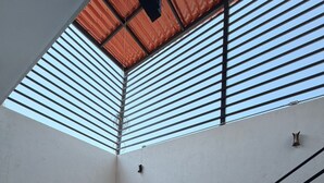 Ein Zimmer mit schrägen Wänden, einer Treppe und einem Fliesenboden.