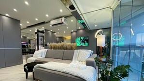 A modern living room with a sofa, a coffee table, and a potted plant. - Paris Luxury Apartment (Barueri)