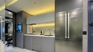 A modern kitchen with stainless steel appliances, a marble countertop, and a built-in oven. - Paris Luxury Apartment (Barueri)