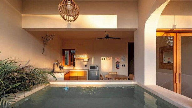 En modern inredning med en swimmingpool, ett köksområde och en matplats.