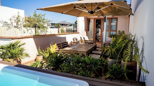 A pool area with a wooden deck, outdoor furniture, and potted plants. - COLÓN · Luxury house with pool and terrace for 6 (Oaxaca)