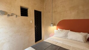 A bedroom with a bed, a headboard, a wall-mounted light, and a small window. - GARCIA 5 · Tiny Room in the heart of Oaxaca (Oaxaca)