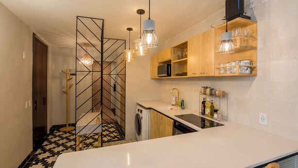 A modern kitchen with a central island, wooden cabinets, and a patterned floor.