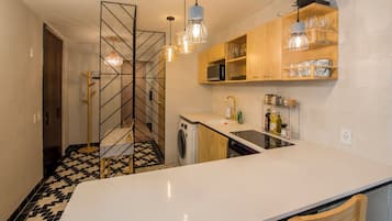 A modern kitchen with a central island, wooden cabinets, and a patterned floor.