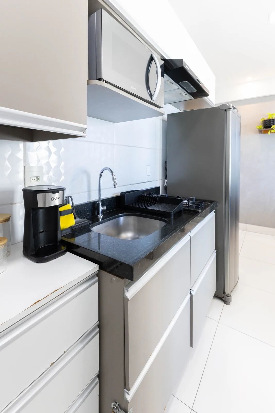 Una cocina moderna con electrodomésticos de acero inoxidable, encimera negra y un lavabo integrado.