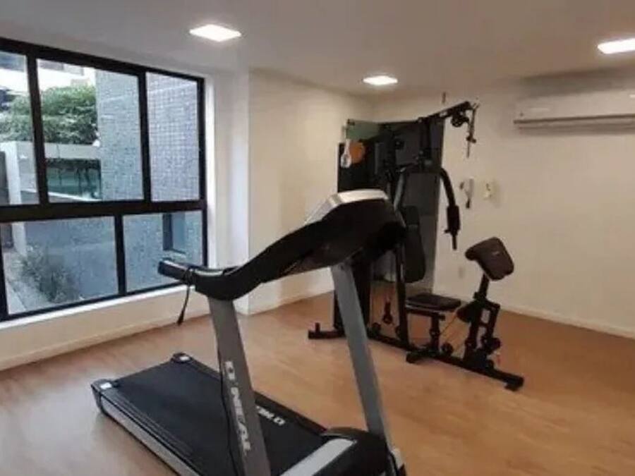 A gym with a treadmill, weight bench, and exercise equipment.