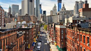 A cityscape with a mix of historic and modern buildings, a clear sky, and a busy street. - Simple, Quiet & Clean w/ Workstations (New York)