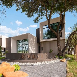 A modern building with a minimalist design, large windows, and a prominent 'BUJI' sign.