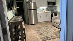 A compact kitchen with a refrigerator, microwave, and stove. - Tranquil 1-bedroom condo with AC in Madeira Beach completely updated . (Madeira Beach)