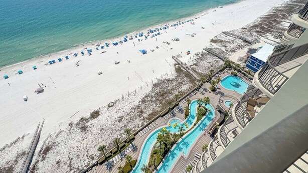 Un complexe hôtelier en bord de mer doté d’une piscine, de parasols et offrant une vue sur l’océan.