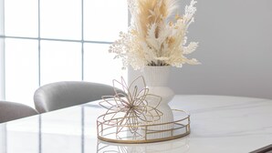 A dining table with a white vase and a gold wire basket, chairs, and a window with a grid pattern. - Stunning 4BR2BA w Parking/Near Downtown/ +Parking (Boston)