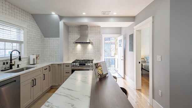 A modern kitchen with a marble countertop, stainless steel appliances, and a large island. - Stunning 4BR2BA w Parking/Near Downtown/ +Parking (Boston)