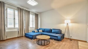 A modern living room with a sectional sofa, a round coffee table, and a floor lamp.