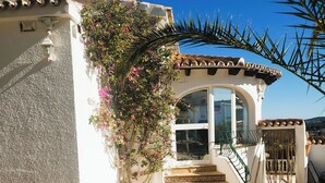 A building with a white facade, a stone wall, and a staircase leading to a covered entrance. - Villa Mitica with Private Pool in Benitachell (El Poble Nou de Benitatxell/Benitachell)