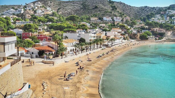 A coastal town with a sandy beach, buildings along the shore, and a hilly backdrop. - Villa Mitica with Private Pool in Benitachell (El Poble Nou de Benitatxell/Benitachell)