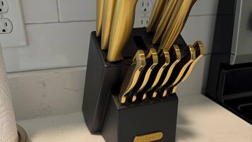 A kitchen counter with a knife block containing several knives.