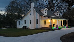A two-story house with a front porch, a driveway, and a well-maintained lawn. - The Corner 82 /High End Nature Escape King beds (Winder)