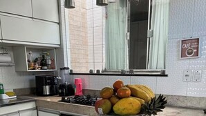 A kitchen with a granite countertop, a fruit bowl, a coffee maker, and a window with a view. - Cozy apartment in Belém, close to the main tourist attractions. (Belém)