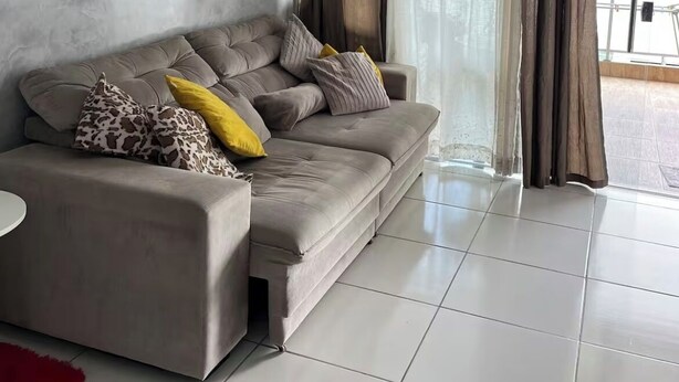 A modern living room with a grey sofa, two framed artworks, and a view through large windows with curtains. - Cozy apartment in Belém, close to the main tourist attractions. (Belém)