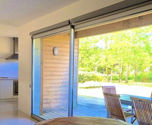 A modern kitchen with a sliding glass door leading to an outdoor deck. - Holiday home, !natural park, nearby Ocean, Forest, Lake (Messanges)