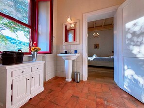 Une salle de bain avec un lavabo, un miroir et une fenêtre.