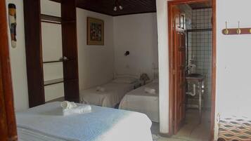 Una habitación con dos camas, baño y una pequeña cocina.