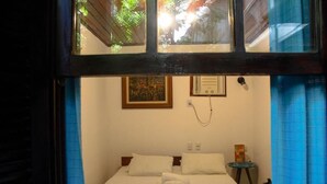 Una camera d'albergo con un letto, un quadro, un telefono e un tavolino.