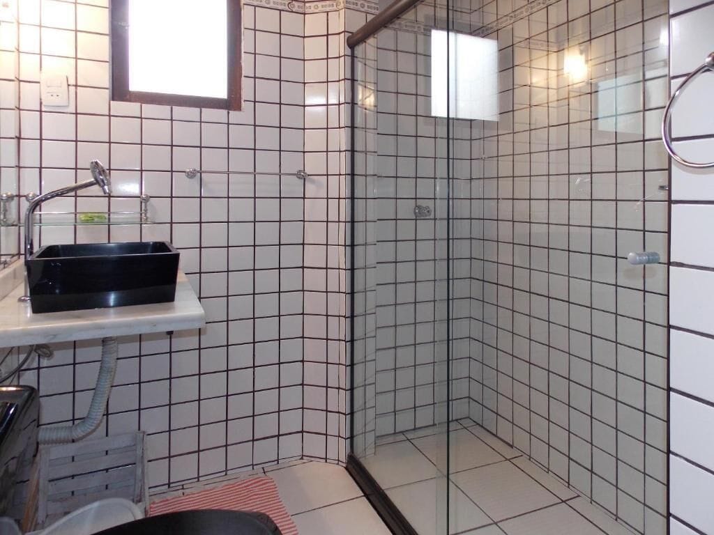 A bathroom with a shower, a sink, and a mirror.
