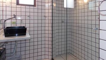 A bathroom with a shower, a sink, and a mirror.