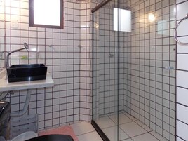 A bathroom with a shower, a sink, and a mirror.