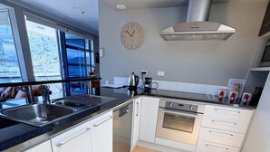Una cocina moderna con lavavajillas, horno y un reloj en la pared.