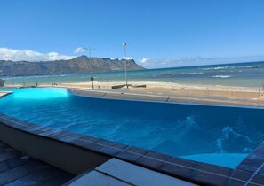 Ein Pool mit Blick auf Strand und Berge.