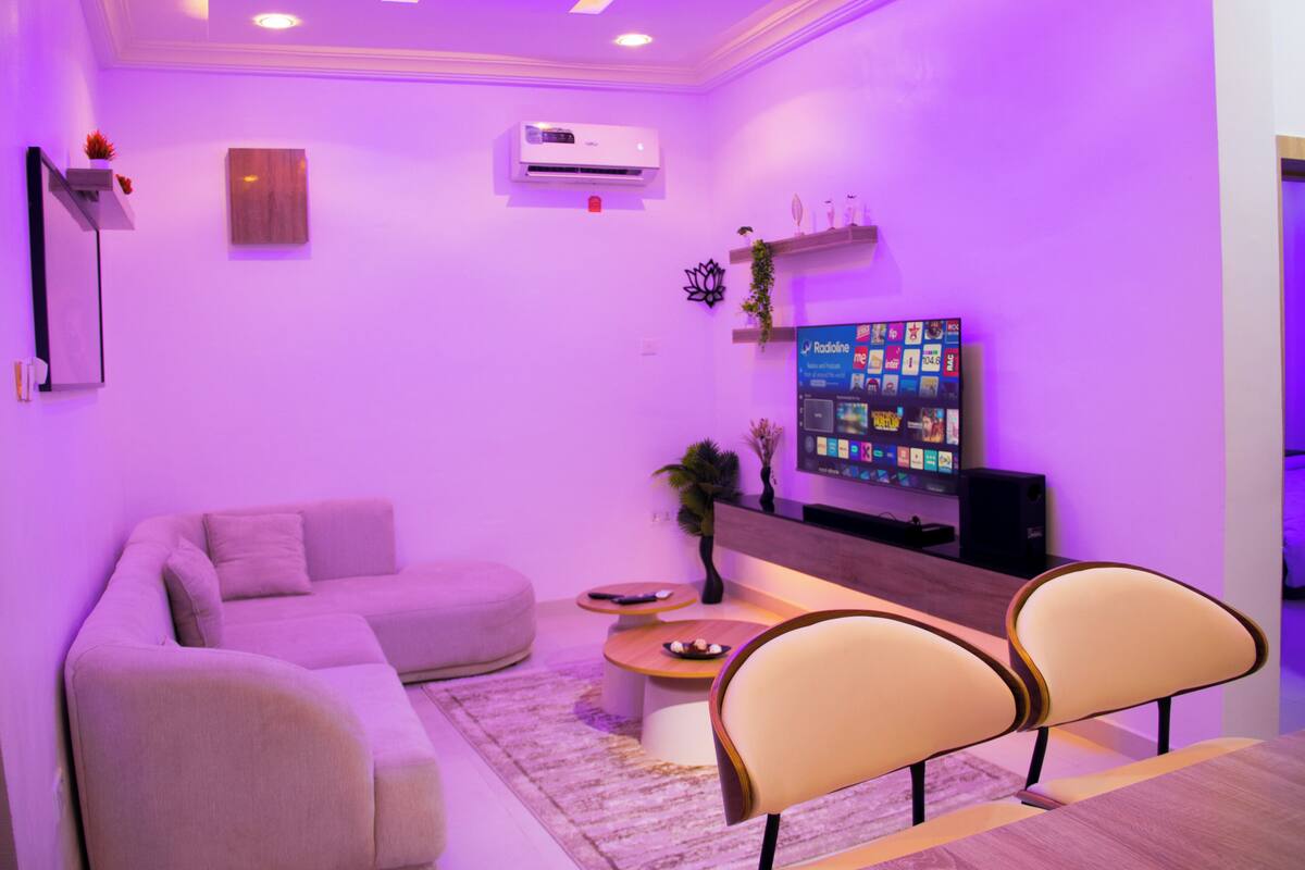 A modern living room with a sectional sofa, a coffee table, and two chairs.