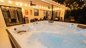 Ein Whirlpool mit Sitzgelegenheit, Deckenventilator und Lichterkette.